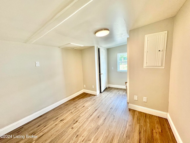 empty room featuring light wood-type flooring and electric panel