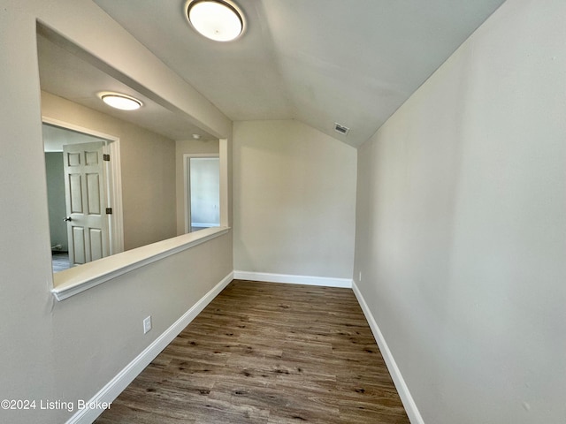 hallway featuring hardwood / wood-style flooring and vaulted ceiling