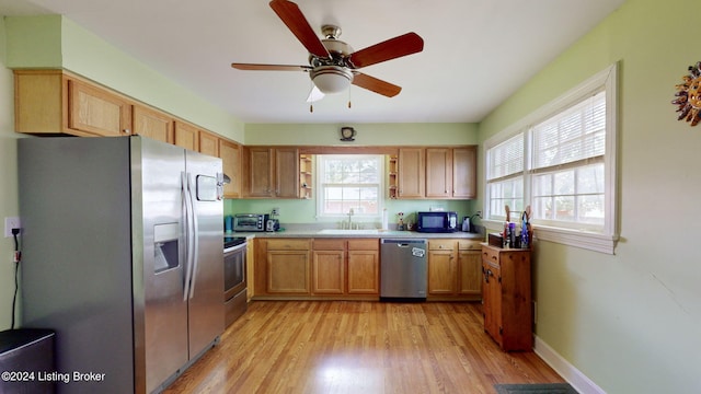 kitchen with stainless steel appliances, light hardwood / wood-style flooring, a wealth of natural light, and sink