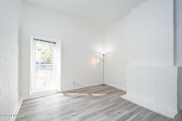 spare room with a fireplace and light hardwood / wood-style floors