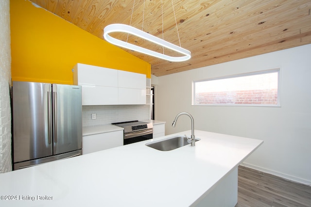 kitchen featuring white cabinetry, sink, hanging light fixtures, lofted ceiling, and appliances with stainless steel finishes