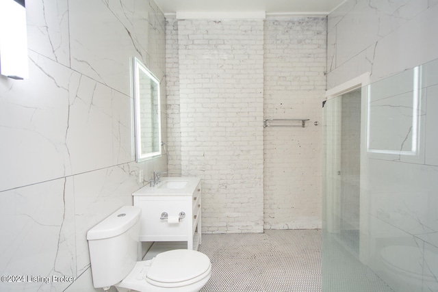 bathroom with vanity, a shower, toilet, and tile walls