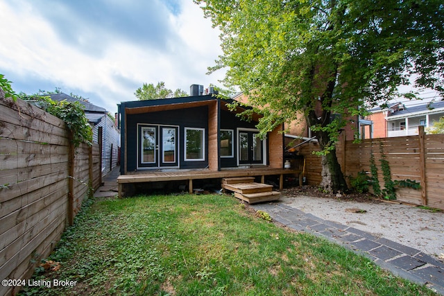 rear view of house with a deck and a yard