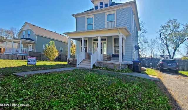 view of front facade featuring covered porch and a front lawn