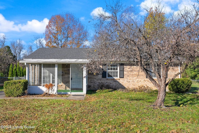 view of front of property with a sunroom and a front yard