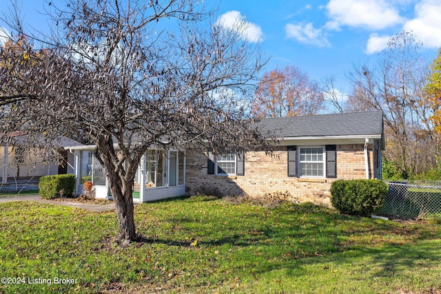 view of front of home with a sunroom and a front yard