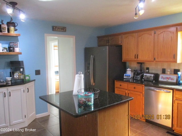 kitchen featuring light tile patterned floors, a center island, stainless steel appliances, and track lighting