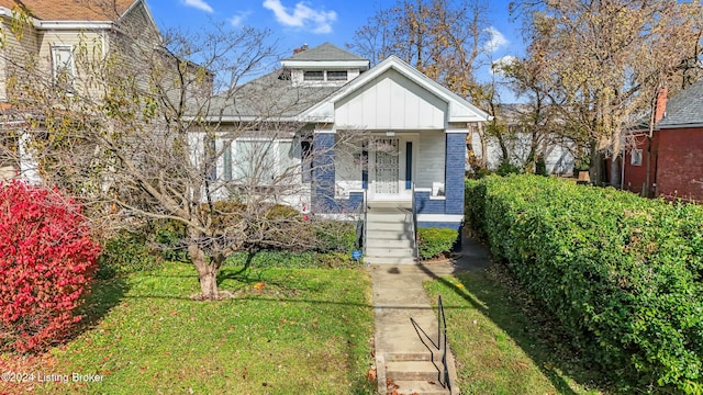 bungalow with covered porch and a front yard