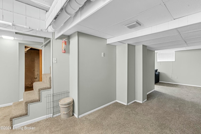 basement with carpet and a drop ceiling