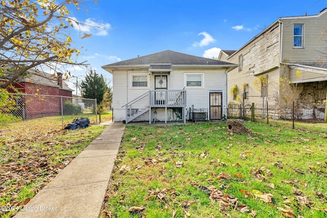 rear view of house featuring a yard