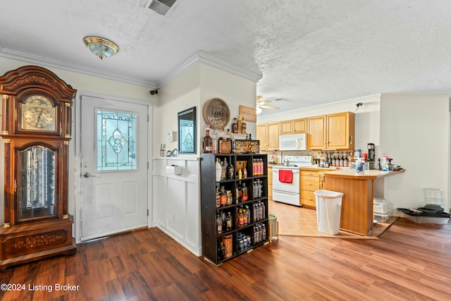 foyer with a textured ceiling, dark hardwood / wood-style flooring, ceiling fan, and crown molding