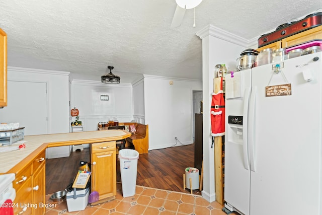 kitchen featuring ceiling fan, light wood-type flooring, a textured ceiling, white fridge with ice dispenser, and ornamental molding