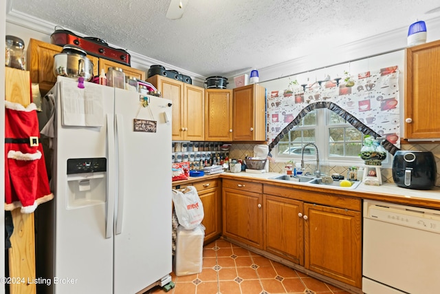 kitchen featuring a textured ceiling, white appliances, sink, and tasteful backsplash