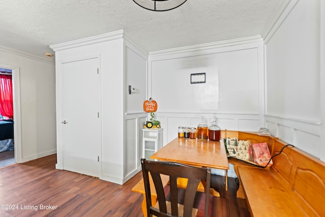 dining space with crown molding, dark hardwood / wood-style flooring, and a textured ceiling