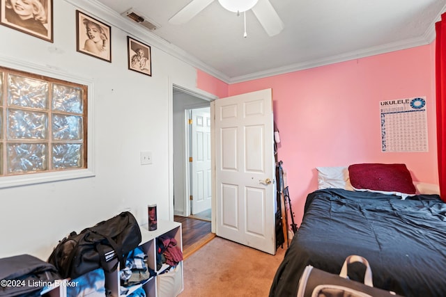 carpeted bedroom featuring ceiling fan and ornamental molding