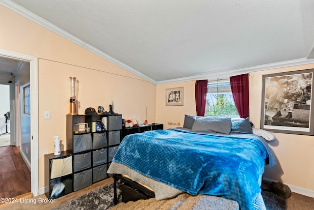 bedroom featuring a textured ceiling, wood-type flooring, crown molding, and vaulted ceiling