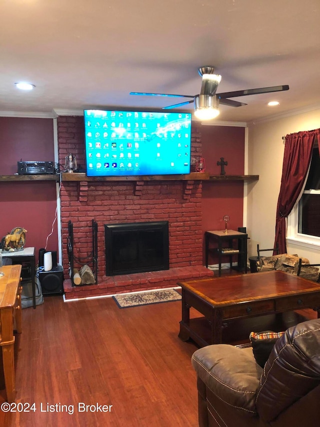 living room with ceiling fan, a fireplace, ornamental molding, and hardwood / wood-style flooring