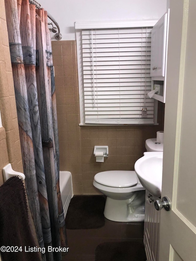 full bathroom with vanity, toilet, tile walls, and shower / tub combo with curtain