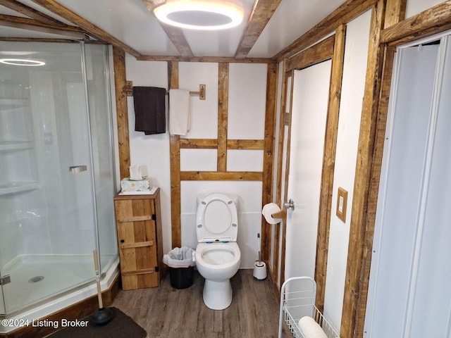 bathroom with hardwood / wood-style floors, toilet, and walk in shower