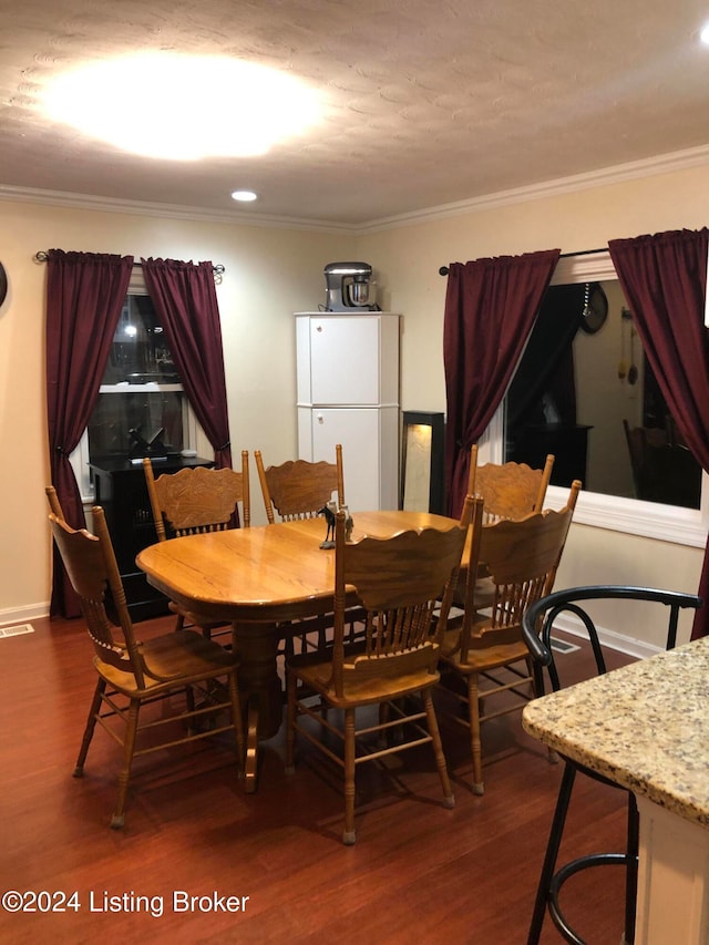 dining area with crown molding and dark wood-type flooring