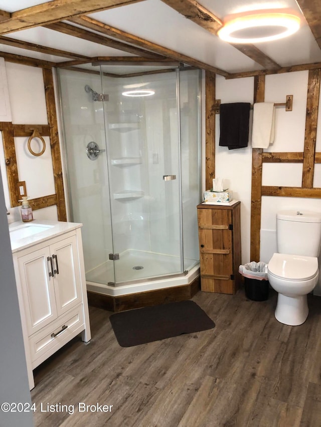 bathroom with hardwood / wood-style floors, vanity, toilet, and walk in shower