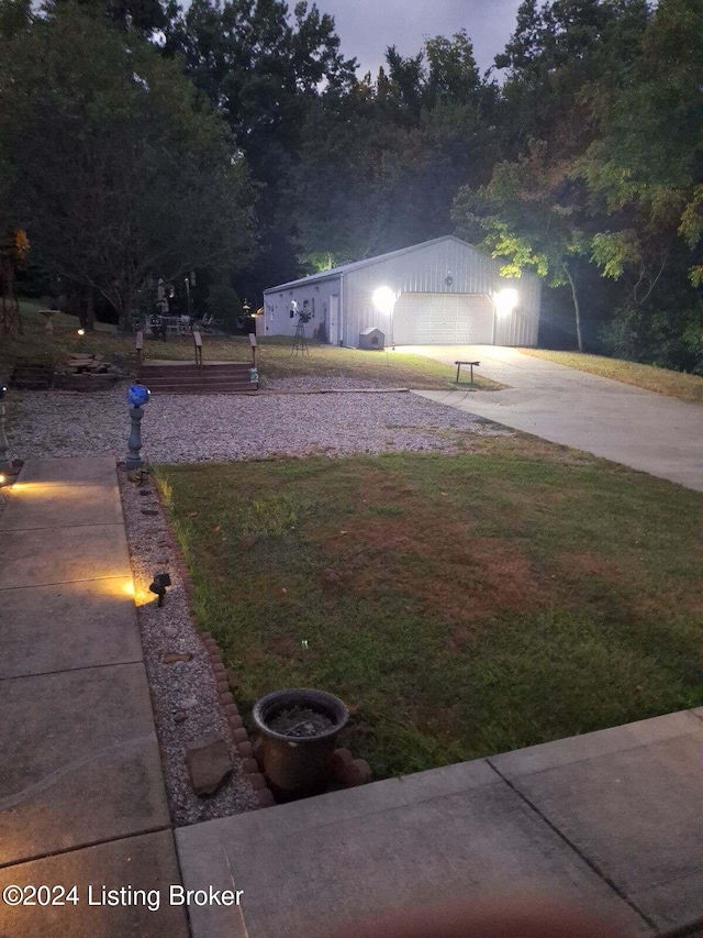 yard at dusk featuring an outbuilding and a garage