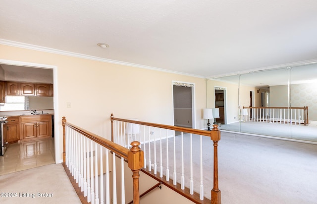 corridor featuring light colored carpet, ornamental molding, and sink