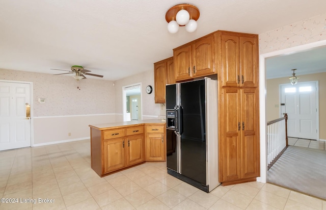 kitchen with kitchen peninsula, black refrigerator with ice dispenser, and ceiling fan