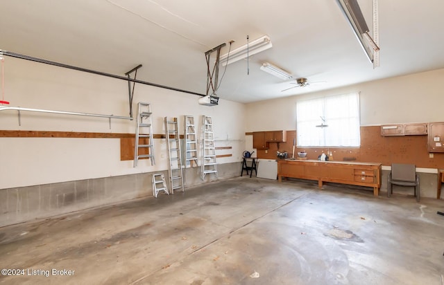 garage featuring a workshop area, a garage door opener, and ceiling fan