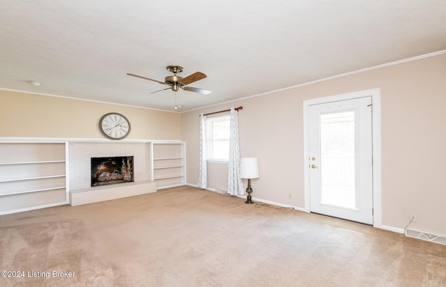 unfurnished living room with ceiling fan, carpet, ornamental molding, and a brick fireplace