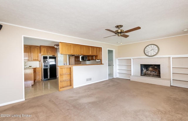 unfurnished living room featuring a textured ceiling, light colored carpet, ceiling fan, crown molding, and a fireplace