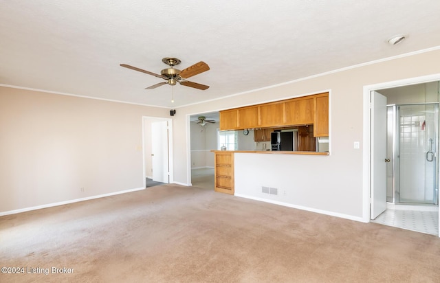 unfurnished living room featuring carpet flooring, ceiling fan, crown molding, and a textured ceiling