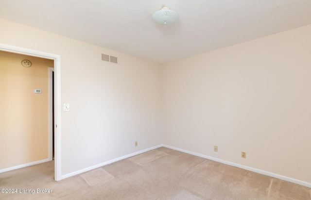 spare room featuring light colored carpet