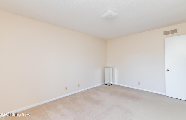 unfurnished room featuring light carpet