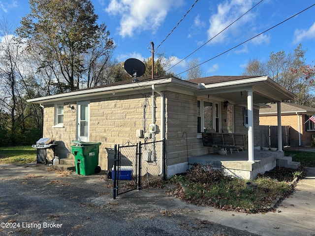 view of side of property featuring covered porch