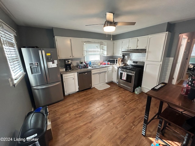 kitchen with backsplash, stainless steel appliances, ceiling fan, light hardwood / wood-style floors, and white cabinetry