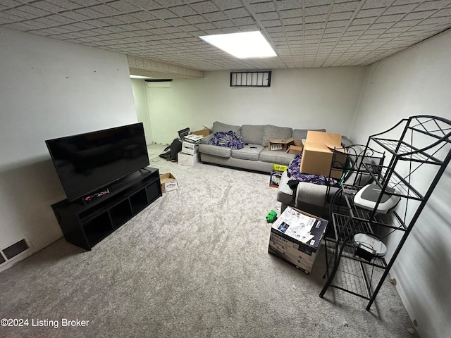 living room with carpet flooring and a paneled ceiling