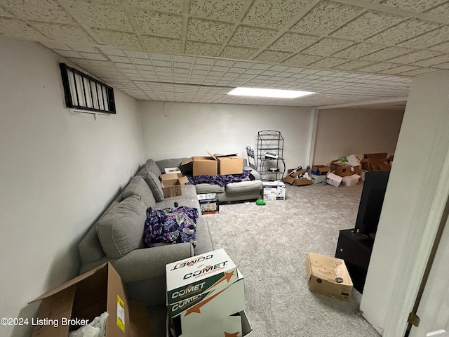 carpeted living room with a paneled ceiling