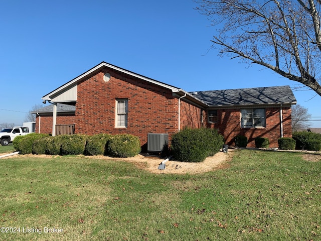 view of side of property with a lawn and central air condition unit