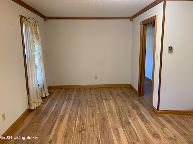 spare room featuring wood-type flooring and ornamental molding