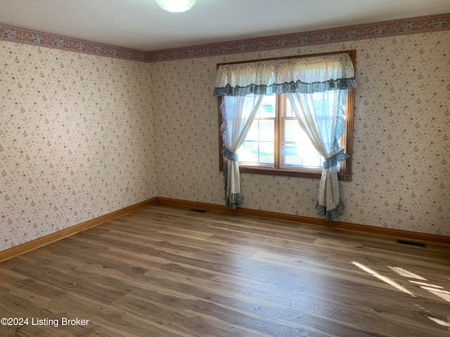 empty room with dark hardwood / wood-style flooring