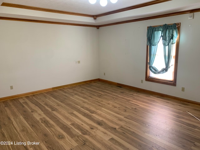 empty room featuring hardwood / wood-style flooring and ornamental molding