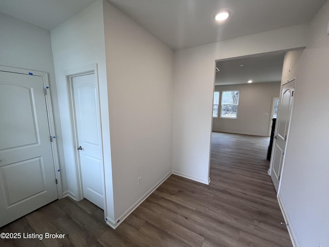 hall with dark wood-style floors, recessed lighting, and baseboards