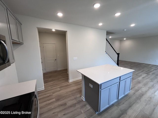 kitchen featuring recessed lighting, light countertops, baseboards, and wood finished floors