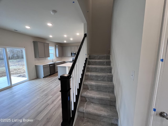 staircase featuring wood finished floors and recessed lighting