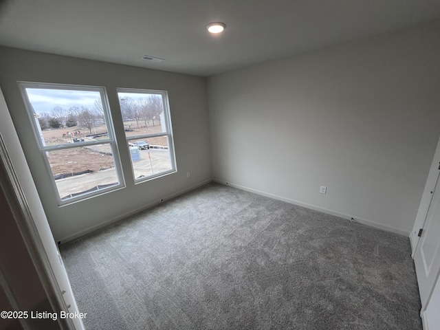 carpeted empty room featuring visible vents and baseboards