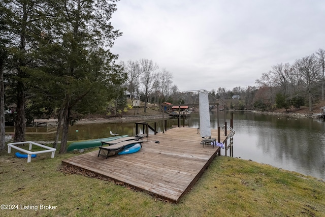 view of dock with a water view and a yard