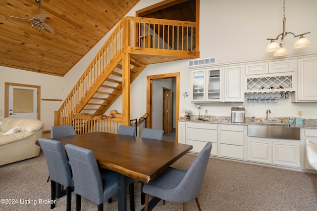 dining room featuring light colored carpet, high vaulted ceiling, wood ceiling, and sink