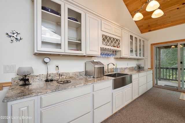 kitchen with white cabinetry, light carpet, sink, and vaulted ceiling