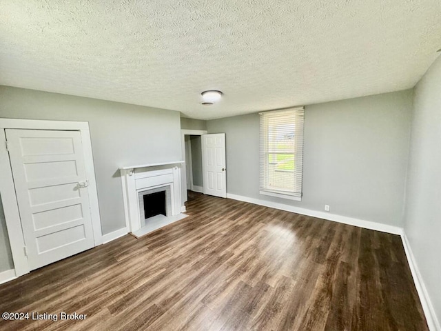 unfurnished living room featuring hardwood / wood-style floors and a textured ceiling